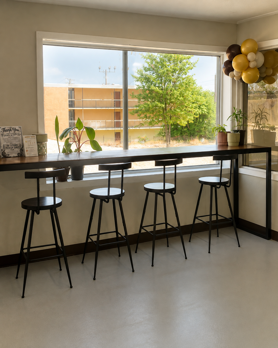 Bar-height counter with stools facing a large studio window